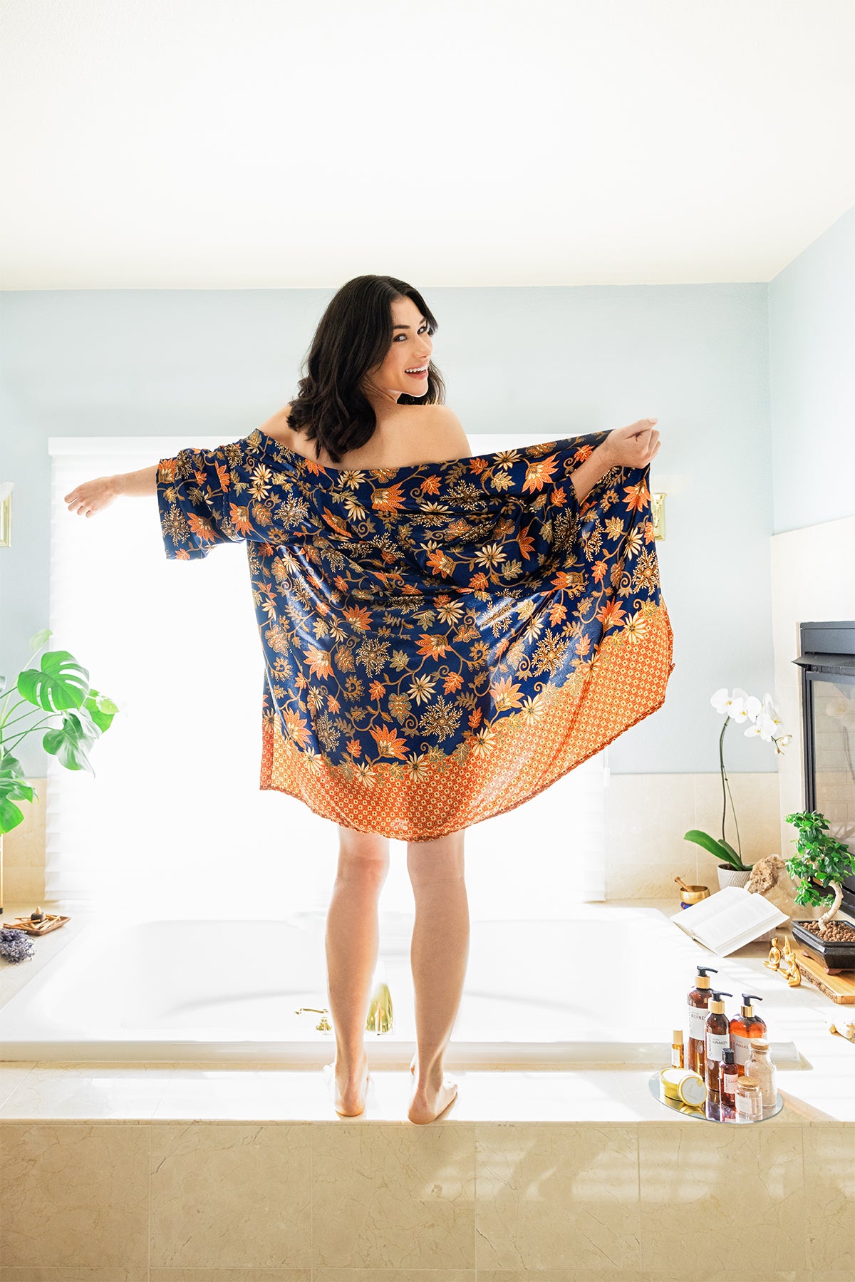 Woman with her robe open standing on a tub