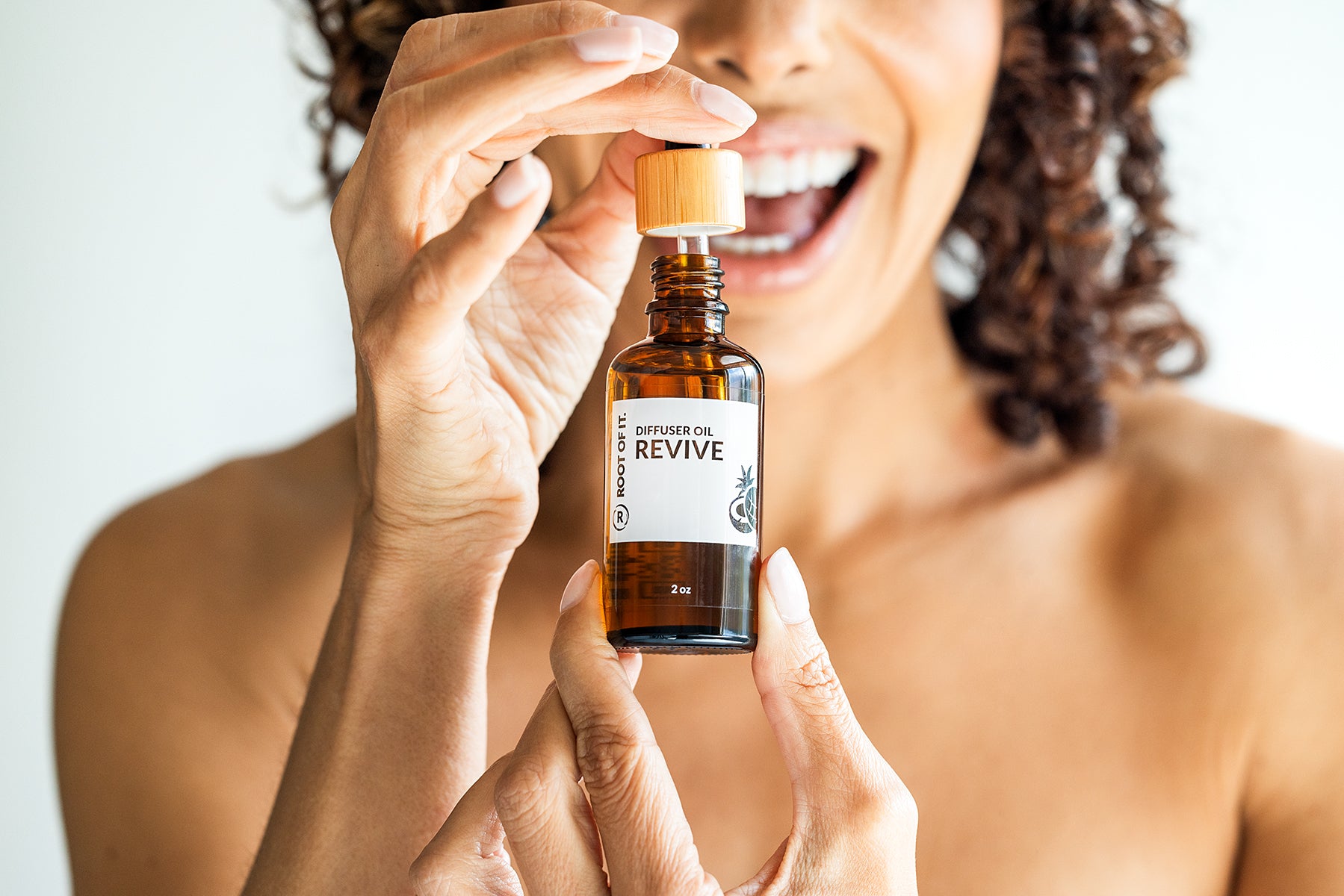 Women with curly hair sharing Revive essential oil